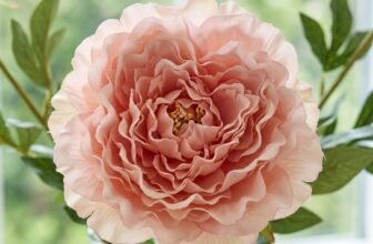 Lush bouquet of realistic artificial blush-pink peonies in a ceramic vase on a styled sideboard